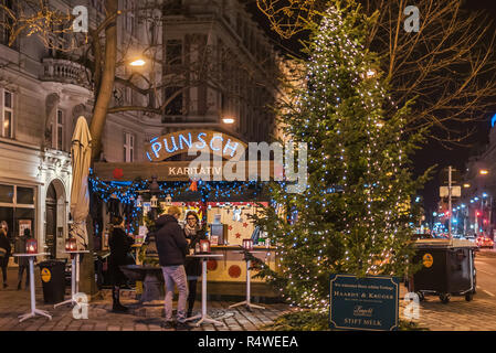 Wien, Österreich - 25. Dezember 2017. Menschen trinken Glühwein vor der traditionellen Wiener Weihnachten stand verkaufen Punch abgewürgt. Warme Getränke stehen eine Stockfoto