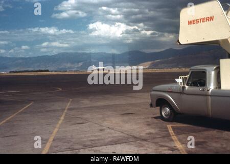 Blick Richtung Osten von einem Flugzeug auf der Landebahn von Salt Lake City Municipal Airport in Salt Lake City, Utah, März, 1965. Rechts unten ist ein Satz von Westlichen mobile Airlines airstairs auf einem Lkw auf dem Asphalt geparkt montiert. () Stockfoto