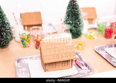 Kinder Partei kleine Lebkuchenhäuser mit Bonbons zu verzieren. Stockfoto