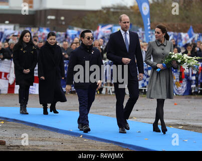 Der Herzog und die Herzogin von Cambridge, begleitet von der Familie des Leicester City Besitzers Vichai Srivaddhanaprabha, legten während eines Besuchs in Leicester Blumen auf der Tribute-Seite in der Nähe des King Power Stadions des Leicester City Football Clubs, um denjenigen zu Tribut zu zollen, die letzten Monat bei dem Hubschrauberabsturz ums Leben kamen. Stockfoto