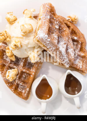 Waffel gekleidet mit Pop Corn, Eis und Schokolade und Karamell Saucen Stockfoto