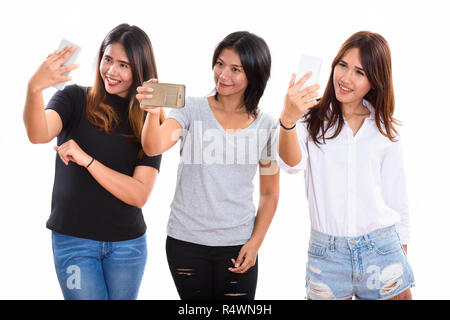 Drei glückliche junge asiatische Frau Freunde lächelnd, während Sie selfi Stockfoto