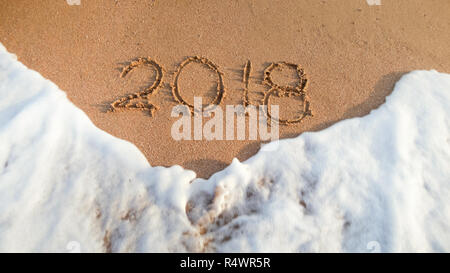 Closeup Bild von 2018 das Neue Jahr auf nassem Sand am Meer Strand geschrieben. Konzept der Feiern und Reisen auf Winterurlaub. Stockfoto