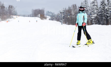 Jugendmädchen in Helm auf dem Berghang bei Ski Resort Stockfoto