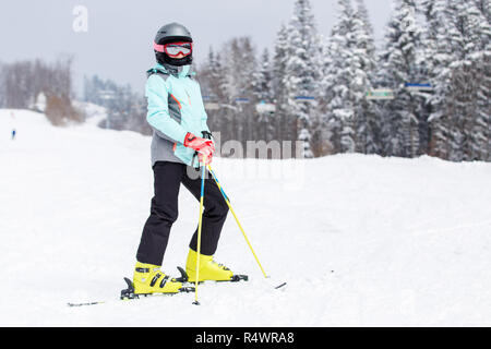 Jugendmädchen in Helm auf dem Berghang bei Ski Resort Stockfoto