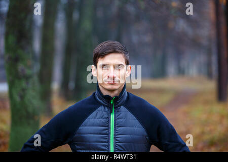 Portrait des jungen Mannes, Joggen im Herbst in der Morgen. Männliche Läufer im Herbst Park Stockfoto