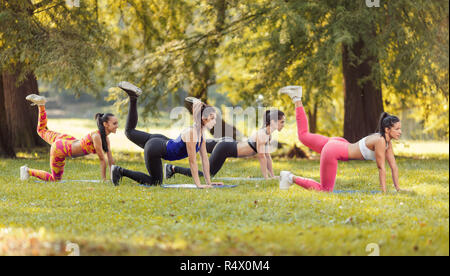 Vier schöne Freundinnen trainieren im Park. Stockfoto