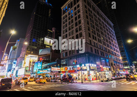 New York City, USA - 30. Juli 2018: Taxi und Geschäfte in der Nacht auf der Seventh Avenue (7. Avenue) Neben der Times Square mit Menschen in Manhattan in New Stockfoto