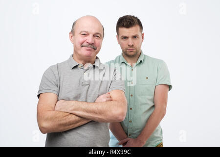 Portrait von lächelnden Vater und Sohn mit Arm um wile stehend zu Hause Stockfoto