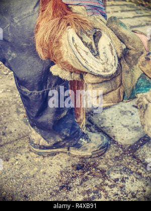 Schmied Reinigung Pferd barfuß Huf ohne Hufeisen. Schneiden verschlissen Keratin. Tier Pediküre. Stockfoto