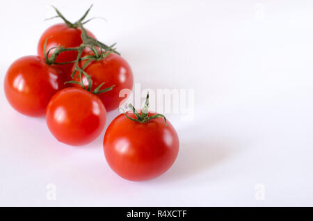 Rot saftige Tomaten mit grünen Schwänze liegen auf einem weißen Hintergrund. Stockfoto