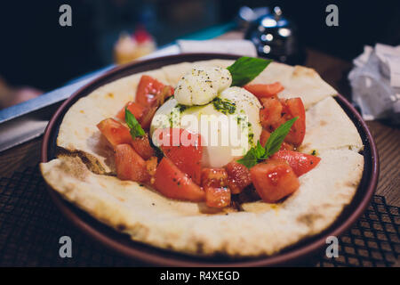 Türkisch und Arabisch traditionellen Ramadan Pide mit Ei auf die Oberseite. Holz Hintergrund. Pizza Margherita ist ein typisch neapolitanischen, mit Tomaten, Mozzarella, frischem Basilikum, Salz und Olivenöl. Stockfoto