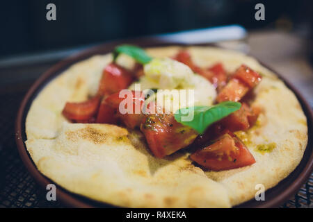 Türkisch und Arabisch traditionellen Ramadan Pide mit Ei auf die Oberseite. Holz Hintergrund. Pizza Margherita ist ein typisch neapolitanischen, mit Tomaten, Mozzarella, frischem Basilikum, Salz und Olivenöl. Stockfoto