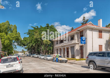 CLANWILLIAM, SÜDAFRIKA, 22. AUGUST 2018: eine Straße, Szene, mit einer Bank, Personen und Fahrzeuge, in Clanwilliam in der Provinz Western Cape Stockfoto