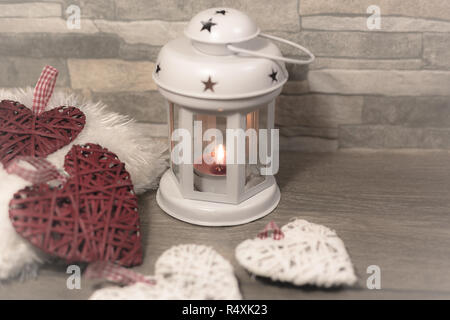 Winter Zusammensetzung mit gemütlichen Kissen, Laterne und Herzen verziert. Winterurlaub Konzept. Stockfoto