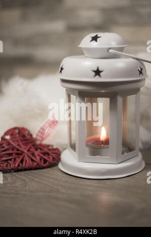Winter Zusammensetzung mit gemütlichen Kissen, Laterne und Herz Ornament. Winterurlaub Konzept. Stockfoto
