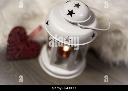 Winter Zusammensetzung mit gemütlichen Kissen, Laterne und Herz Ornament. Winterurlaub Konzept. Stockfoto