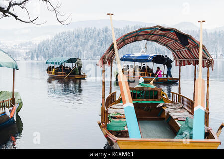 BLED, Slowenien - Januar 2015: schiffer Transport Touristen auf die Insel auf dem See. Leere Boote im Vordergrund. Stockfoto