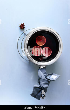 Glühwein in Aluminium Kasserolle auf grau Holztisch. Weihnachten und Winter wärmendes Getränk. Ansicht von oben. Flach Stockfoto