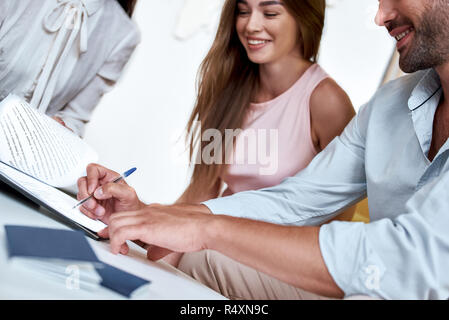 Junge paar schöne unterzeichnen Vertrag für einen Urlaub. Close-up, Reisebüro Stockfoto