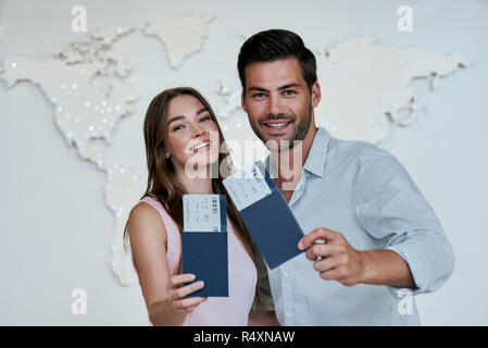 Portrait von freudiger froh Paar hält Reisepass mit fliegenden Karten in den Händen Stockfoto