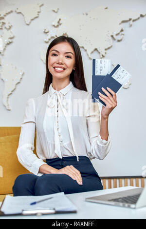 Junge Frau Reisebüro mit Flug Tickets in den Händen Stockfoto