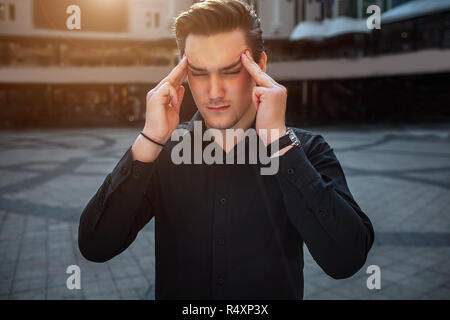 Junge Menschen stehen außerhalb und Finger auf Lot halten. Er hält die Augen geschlossen. Es ist sonnig draussen. Stockfoto