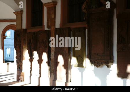 Aschaffenburg, 17. November 2018: Eine historische Kolonnade der Stiftskirche im Sonnenlicht mit alten Platten und reliquiare November Stockfoto