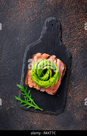 Gesunde Toast mit Lachs und Avocado rose. Ansicht von oben Stockfoto