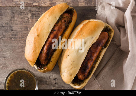 Choripan. Traditionelle Argentinien Sandwich mit Chorizo und chimichurri Sauce auf hölzernen Tisch Stockfoto