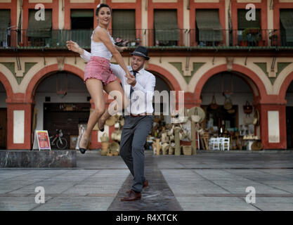 Ziemlich Lindy Hop Tänzer sprang beim Tanzen mit ihrem Partner in einem Spanischen Platz. Stockfoto