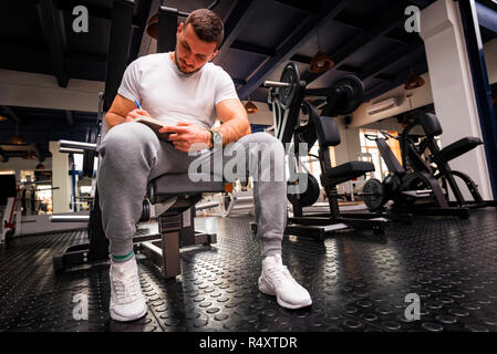 Fitness Trainer schreibt Workout Plan close up in der Turnhalle Stockfoto