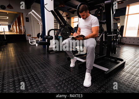 Fitness Trainer schreibt Workout Plan close up in der Turnhalle Stockfoto
