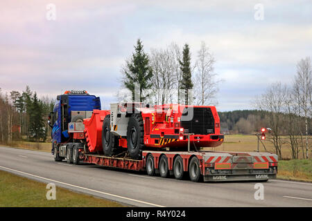 Salo, Finnland - 23. November 2018: Volvo FH 16 750 Auflieger von Lavettikuljetus Ylitalo & Vahtera Oy hols Sandvik LH 517 u-Lader auf die Straße. Stockfoto