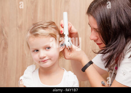 Weibliche Kinderarzt untersucht Ohr des kleinen Mädchens. Arzt mit einem Otoskop oder auriscope Gehörgang und Trommelfell Membran zu prüfen. Kind HNO prüfen Konzept Stockfoto