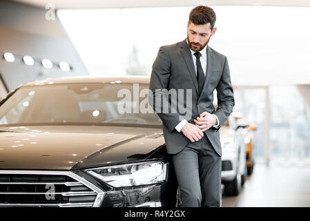 Porträt eines eleganten Geschäftsmann stand in der Nähe der luxuriösen Auto im Showroom Stockfoto