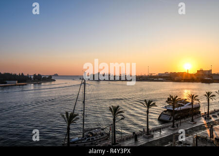 Die Sonne über dem Hafen Port als Boote Dock entlang der Uferpromenade in der Küstenstadt Brindisi, Italien, in der Region Apulien Stockfoto