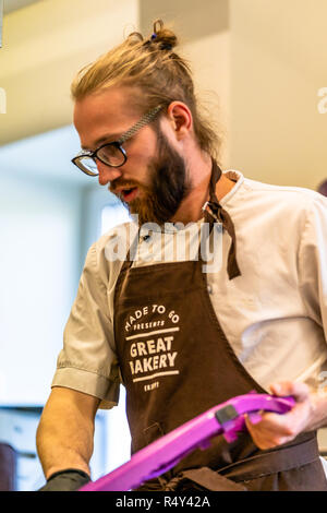 Männliche Chef Schneiden Aubergine in der Küche - mit Handschuh auf seiner Hand Stockfoto