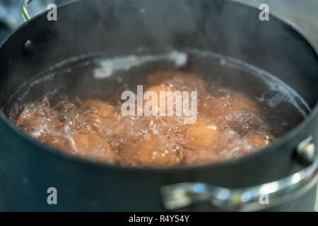 Eier kochen in Wasser - Detailansicht mit Rauch teilweise für den Frame Stockfoto