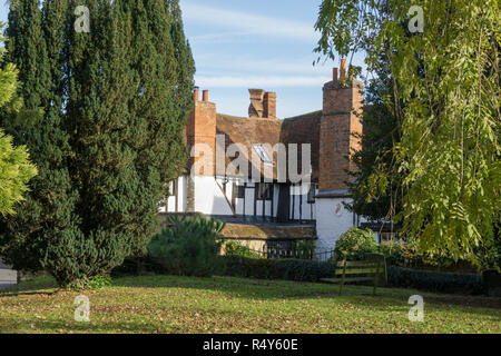 Die Twisted Chimney House gesehen aus dem alten Kirchhof, Buckingham, Großbritannien; eine Elisabethanische Haus für seinen unverwechselbaren twisted Rot gemauerten Schornstein festgestellt. Stockfoto