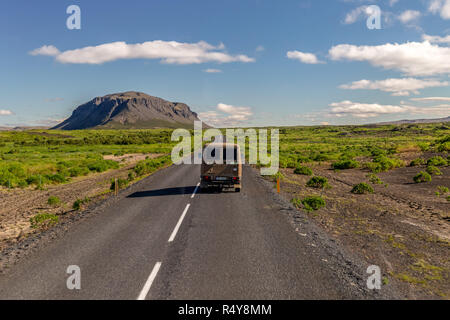 Ein Wohnmobil auf eine typische Straße in Island, die vulkanische Landschaft. Stockfoto