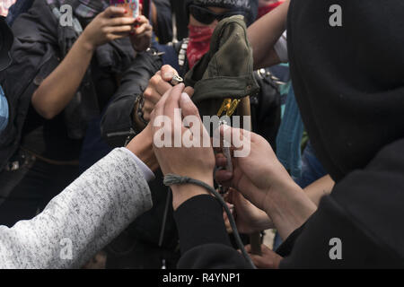 November 28, 2018 - Menschen, die in der März der Studenten für öffentliche Bildung in Bogotà¡teilnehmen, brennen Sie eine Kappe von einem Polizisten. Credit: Daniel Garzon Herazo/ZUMA Draht/Alamy leben Nachrichten Stockfoto
