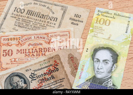 Hyperinflation - 2 klassische Fälle: Deutschland 1920 (1 Milliarden auf 100 Milliarden Mark Noten), mit venezolanischen 100.000 Bolivar Banknote. Stockfoto