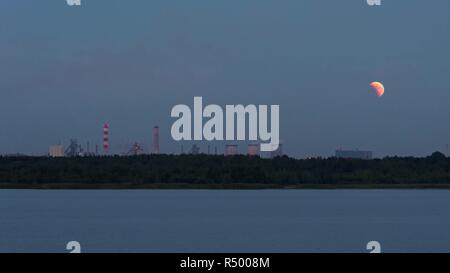 Panoramablick auf Moon eclipse über das Industriegebiet in Dabrowa Gornicza, Polen. Zeitraffer Stockfoto