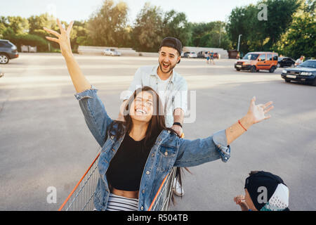 Vati Trägt Mama in einem Wagen mit einem Supermarkt Stockfoto