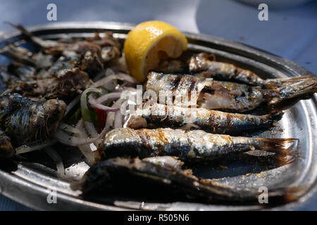 Auf dem ovalen Metall Teller liegt die gebratenen Fisch. Stockfoto