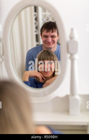 Ein liebevolles Paar bewundern Sie einen Spiegel vor ein Foto schießen Stockfoto