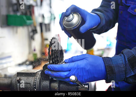 Fahrrad, Reparatur und Wartung. Fahrrad Service, Installation Umwerfer Mann strafft und schmiert das Schaltwerk in den Bike serviceman. Der Mann repariert das Fahrrad Fahrrad reparieren Fahrrad Service, Fahrrad reparieren Stockfoto