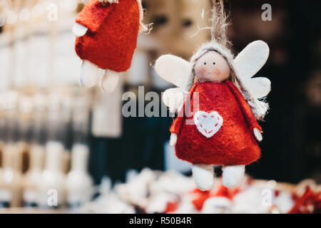 Nahaufnahme von Filz rote und weiße Engel Christbaumschmuck auf Verkauf zu einem Europäischen Weihnachtsmarkt. Stockfoto