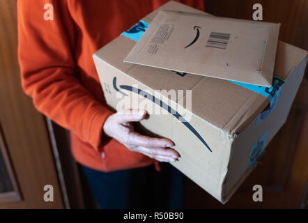 Valencia, Spanien - November 28, 2018: Frauen, die Amazon Prime Package. Geliefert amazon Box nach dem schwarzen Freitag und Cyber Monday Rabatte. Kleine bin Stockfoto